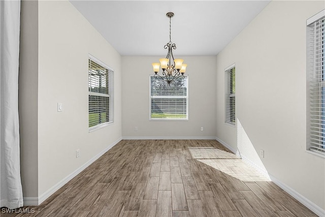 unfurnished dining area featuring an inviting chandelier