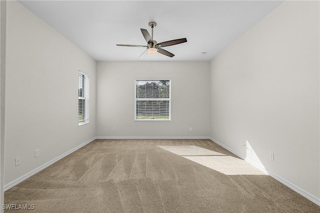 unfurnished room with light colored carpet and ceiling fan