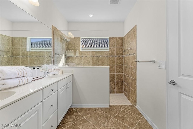 bathroom featuring tiled shower, tile patterned floors, and vanity