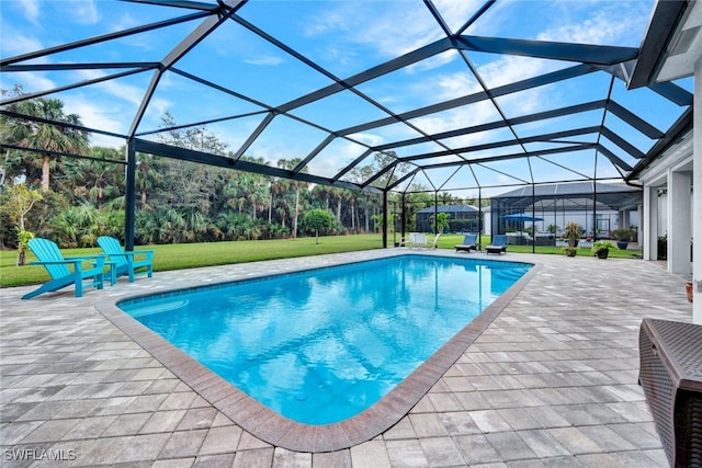 view of swimming pool with a yard, a patio area, and glass enclosure