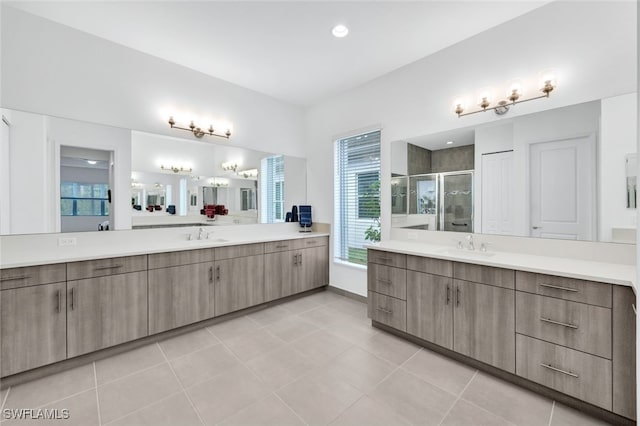 bathroom with a shower with shower door, tile patterned floors, and vanity