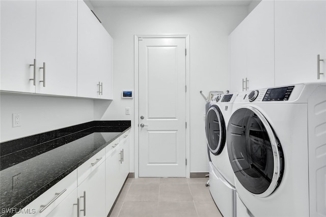 laundry room with washer and clothes dryer, light tile patterned floors, and cabinets