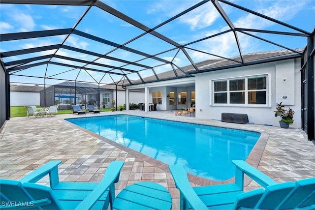 view of pool with a patio area and glass enclosure