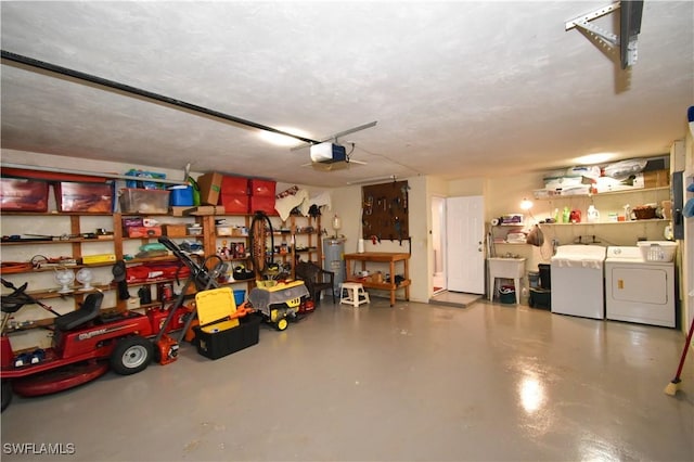 garage featuring a garage door opener, independent washer and dryer, electric water heater, and sink