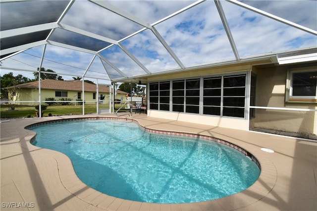 view of pool featuring glass enclosure and a patio