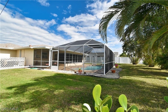 back of property featuring a lanai, a yard, and a fenced in pool