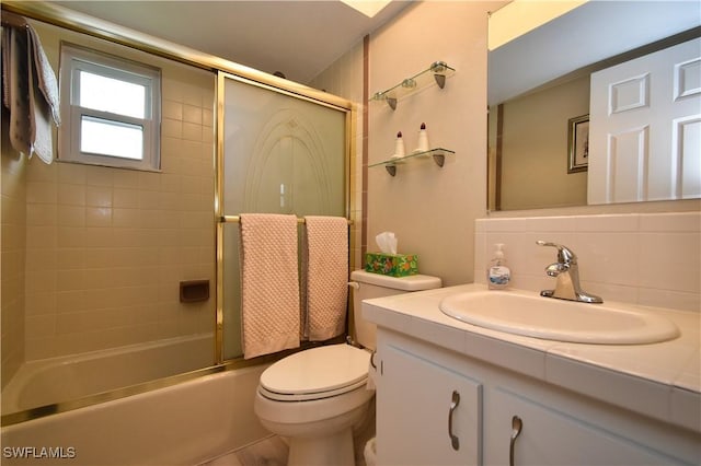 full bathroom with decorative backsplash, toilet, vanity, and combined bath / shower with glass door