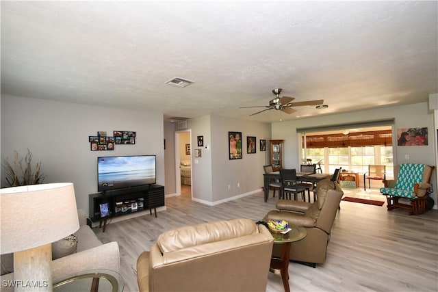 living room with light hardwood / wood-style floors and ceiling fan