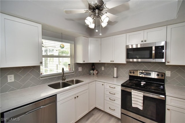 kitchen featuring ceiling fan, tasteful backsplash, sink, white cabinetry, and stainless steel appliances