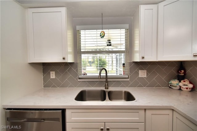 kitchen featuring light stone countertops, dishwasher, white cabinetry, decorative backsplash, and sink