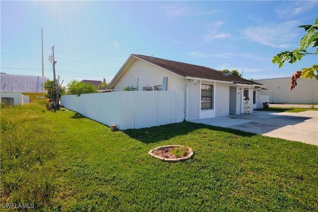 view of property exterior featuring a lawn and a patio