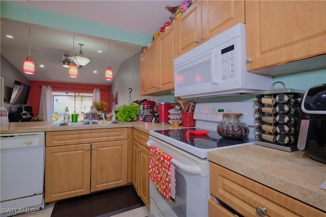 kitchen featuring lofted ceiling, white appliances, sink, and hanging light fixtures