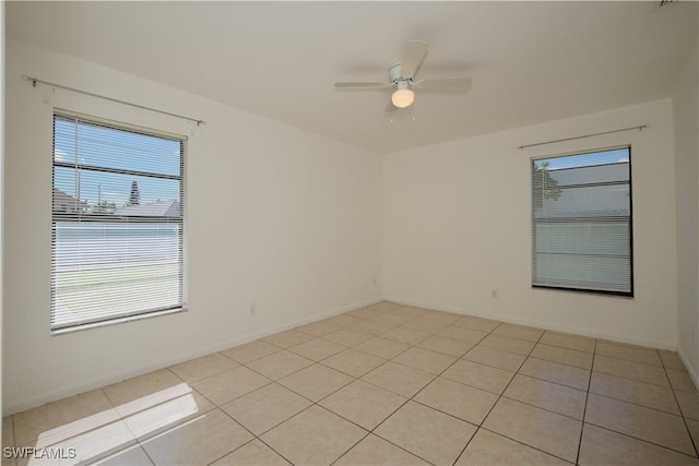 tiled spare room featuring ceiling fan