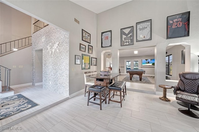 dining space with light tile patterned floors, a high ceiling, and billiards