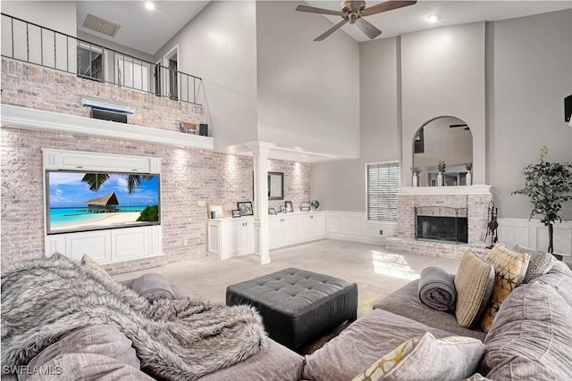 carpeted living room with ceiling fan and a towering ceiling