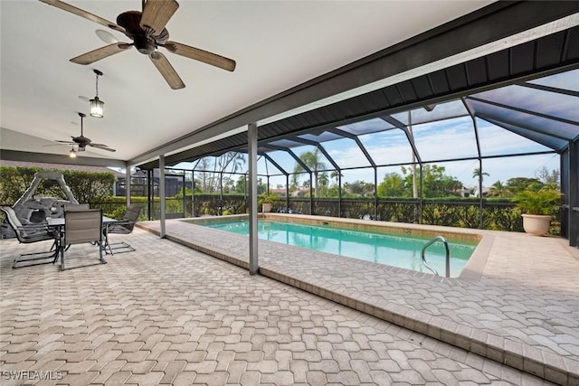 view of pool featuring glass enclosure, a patio area, and ceiling fan