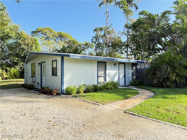 single story home with cooling unit and a front yard