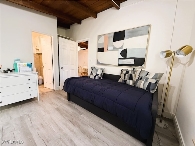 bedroom with beamed ceiling, wooden ceiling, light hardwood / wood-style floors, and ensuite bath