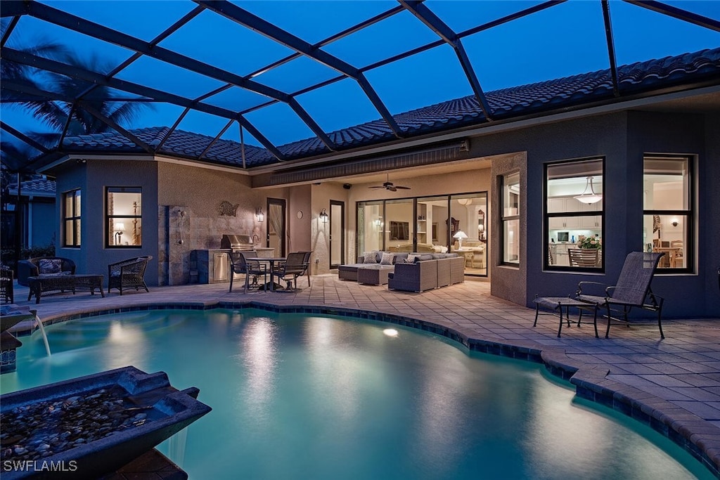 view of swimming pool featuring an outdoor living space, a patio, ceiling fan, and glass enclosure