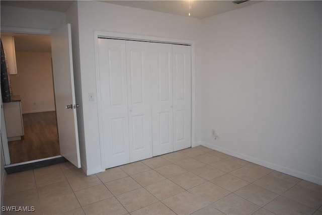 unfurnished bedroom featuring a closet and light tile patterned floors