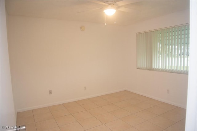 tiled spare room with ceiling fan