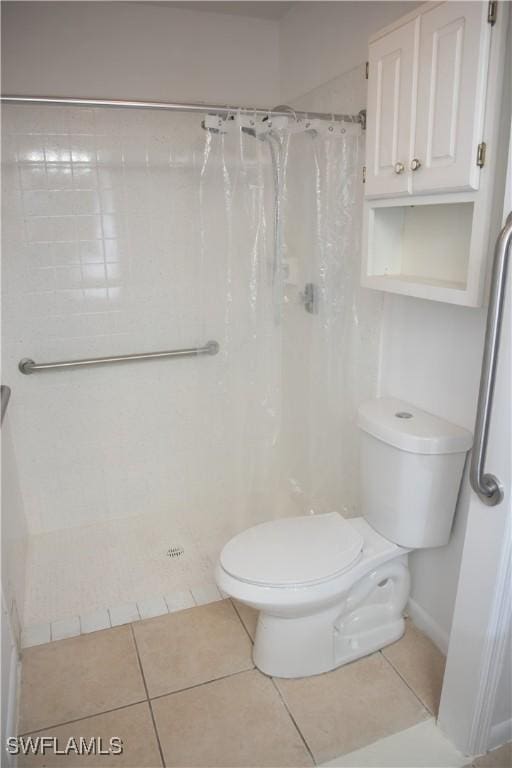 bathroom with toilet, tile patterned flooring, and a shower with shower curtain