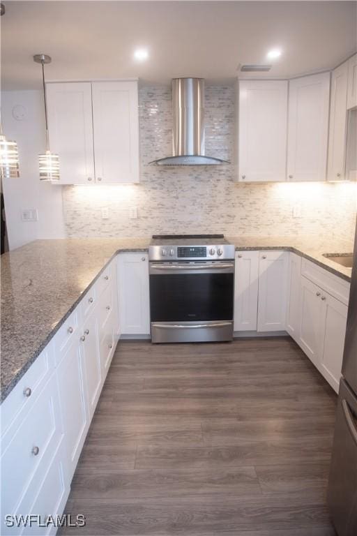 kitchen with white cabinets, wall chimney exhaust hood, dark wood-type flooring, hanging light fixtures, and stainless steel electric range