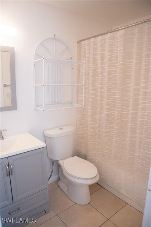 bathroom with vanity, toilet, a shower with shower curtain, and tile patterned flooring