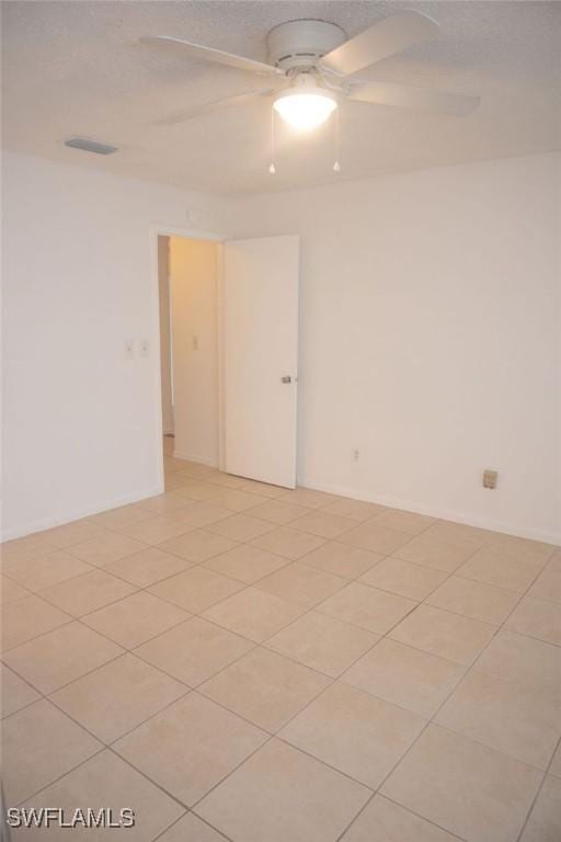 empty room featuring light tile patterned flooring and ceiling fan