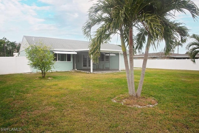 rear view of property with a yard