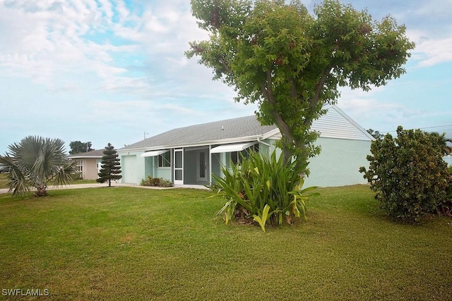 rear view of house featuring a yard