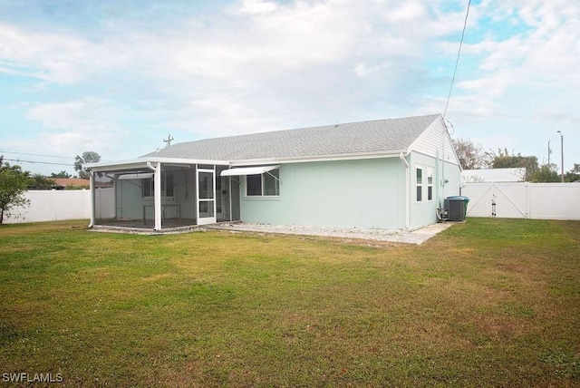 back of property featuring cooling unit, a sunroom, and a lawn