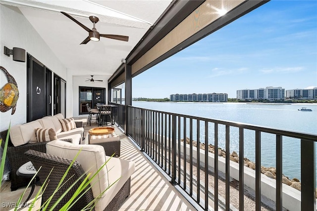 balcony with outdoor lounge area, ceiling fan, and a water view