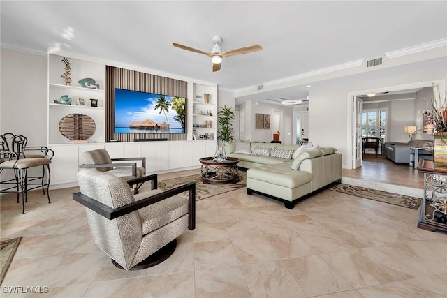 living room featuring built in shelves, crown molding, and ceiling fan