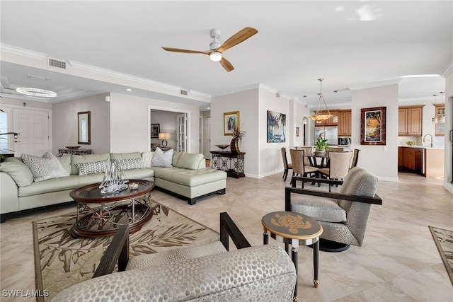 living room featuring ceiling fan with notable chandelier, ornamental molding, and sink