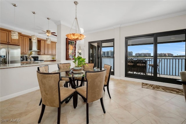 tiled dining room with ceiling fan, a water view, and crown molding