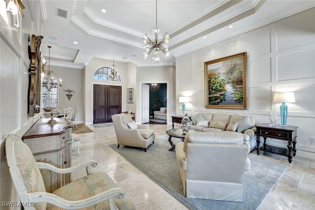 living room with a tray ceiling, ornamental molding, and a notable chandelier