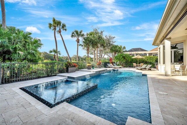 view of swimming pool with pool water feature and a patio