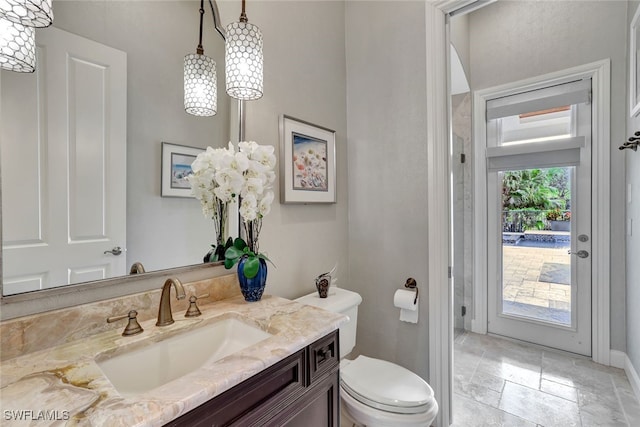 bathroom with toilet, plenty of natural light, and vanity