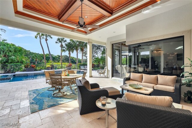 view of patio featuring ceiling fan, pool water feature, a fenced in pool, and outdoor lounge area