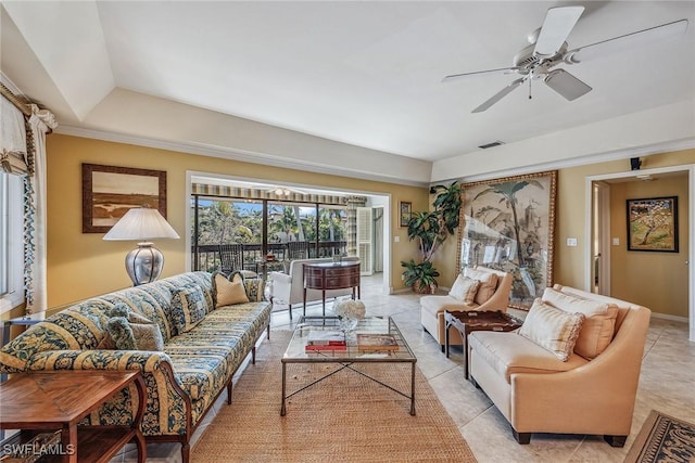 living room featuring a tray ceiling, ceiling fan, and light tile patterned flooring