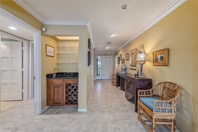 hallway with ornamental molding, sink, and light tile patterned floors