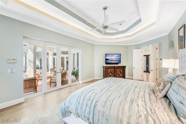 bedroom with french doors, a raised ceiling, ceiling fan, ornamental molding, and light wood-type flooring