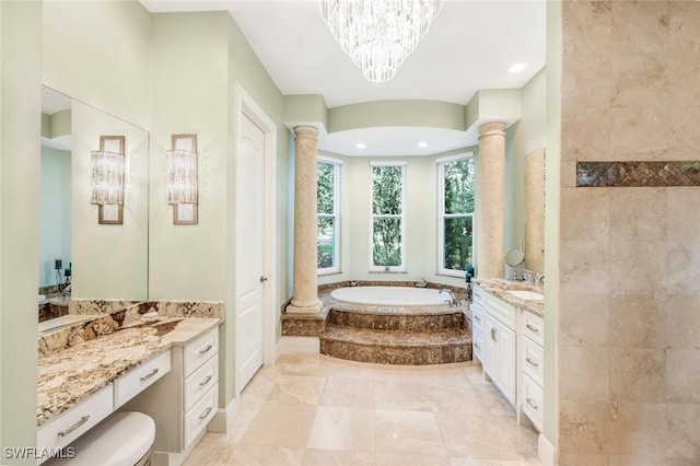 bathroom featuring a relaxing tiled tub, ornate columns, vanity, and a chandelier