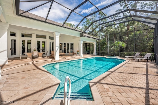 view of swimming pool with an in ground hot tub, a patio, glass enclosure, and ceiling fan