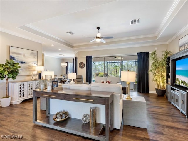 living room featuring dark wood-type flooring, a raised ceiling, and ceiling fan