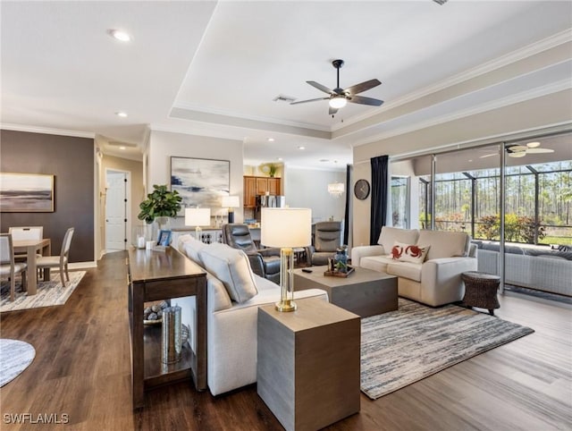 living room featuring ceiling fan, dark hardwood / wood-style floors, ornamental molding, and a raised ceiling