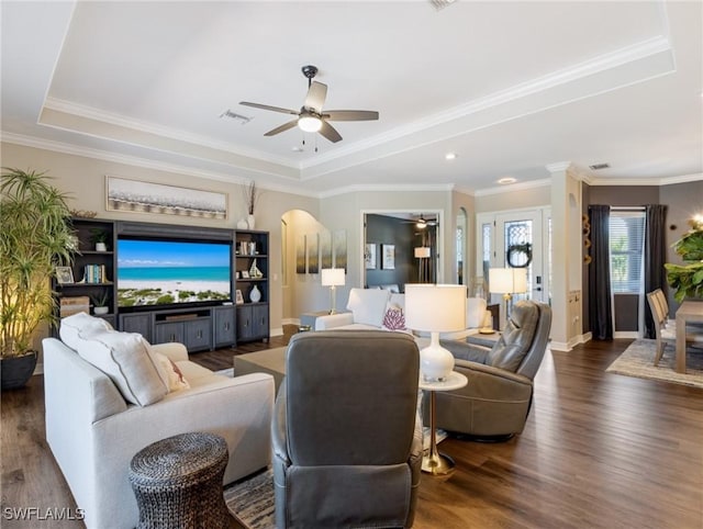 living room with ceiling fan, crown molding, dark hardwood / wood-style floors, and a raised ceiling