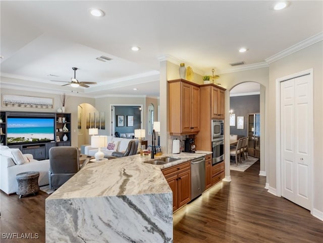 kitchen with appliances with stainless steel finishes, sink, ornamental molding, kitchen peninsula, and ceiling fan