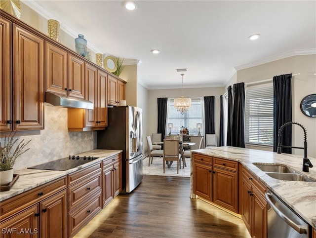 kitchen featuring appliances with stainless steel finishes, decorative light fixtures, decorative backsplash, sink, and a chandelier